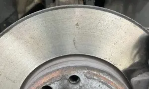 Nahaufnahme einer Bremsscheibe mit leichtem Rost. Die Oberfläche zeigt feine Rillen und einige gelbliche Spuren, die auf beginnenden Rost hindeuten.