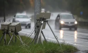Blitzer am Straßenrand im Regen. Autos fahren vorbei. Wie viel Toleranz bei Blitzern ist erlaubt?