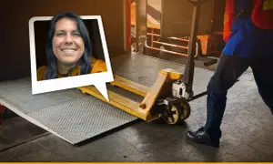 Frau lächelt, während ein Gabelhubwagen bereitsteht, um Waren auf dem Gehweg zu be- und entladen.