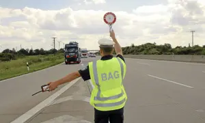 BAG-Kontrolleur regelt den Verkehr auf der Autobahn. LKW werden angehalten.