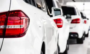 Reihe weißer Autos, bereit, als Poolfahrzeug mit nach Hause genommen zu werden.