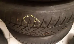 Eine Schraube im Reifen markiert den Schaden, der für die Reifenreparatur vorbereitet wird.