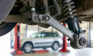 Auto-Aufhängung mit defektem Querlenker. Symptome wie Klappern oder schlechte Straßenlage deuten auf Probleme hin.