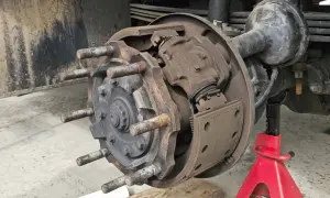 Detailaufnahme einer Trommelbremse mit freiliegenden Bremsbelägen und Radbolzen. Die Handbremse einstellen erfordert hier präzises Arbeiten.