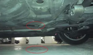 Unterseite eines Autos mit roten Kreisen, die auf Kondenswasser der Klimaanlage im Auto hinweisen.