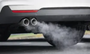 Ein Auto im Leerlauf stößt Rauch aus seinen zwei Auspuffrohren aus.