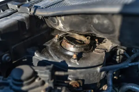 Rostiges Domlager im Motorraum. Mögliche domlager defekt symptome sind Geräusche beim Lenken oder Fahren.