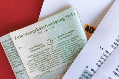 Fahrzeugschein (Zulassungsbescheinigung Teil I) und ein ADAC-Dokument. Die Bedeutung von Kfz-Papieren ist hier klar ersichtlich.