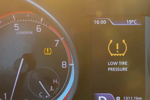 Warnleuchte für **druckverlust reifen** leuchtet auf dem Armaturenbrett. Die Anzeige zeigt "LOW TIRE PRESSURE".