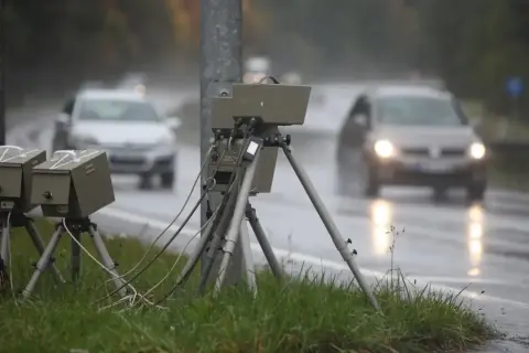Blitzer am Straßenrand im Regen. Autos fahren vorbei. Wie viel Toleranz bei Blitzern ist erlaubt?