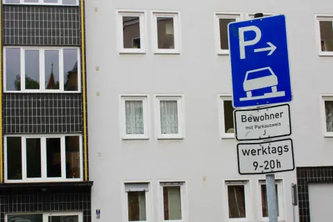 Parken für Bewohner mit Parkausweis werktags 9-20 Uhr, sonst Strafe. Ein blaues Schild mit Auto und Pfeil weist den Weg.
