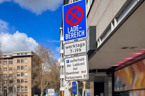 Verkehrsschilder weisen auf eine Ladezone hin, in der werktags von 7-19 Uhr Parken verboten ist. Außerhalb der Ladezeit ist Parken nur für Anwohner mit Parkausweis gestattet.