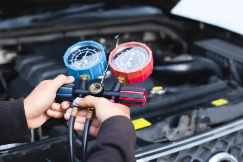 Hände halten ein Klimaanlagen-Manometer-Set, um zu prüfen, warum die klimaanlage funktioniert nicht.