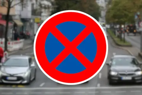 Verkehrsschild "Absolutes Halteverbot". Parken im absoluten Halteverbot strafe droht. Autos fahren auf einer Straße.