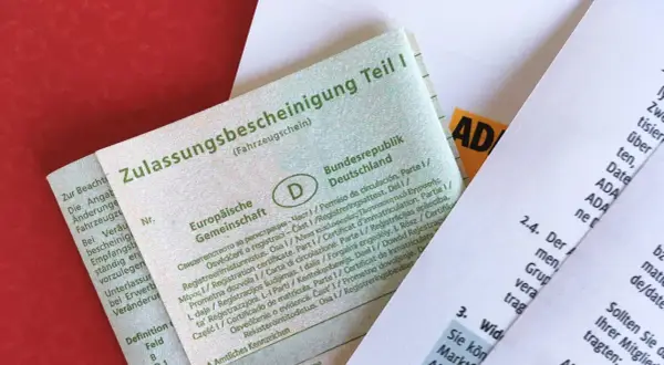 Fahrzeugschein (Zulassungsbescheinigung Teil I) und ein ADAC-Dokument. Die Bedeutung von Kfz-Papieren ist hier klar ersichtlich.