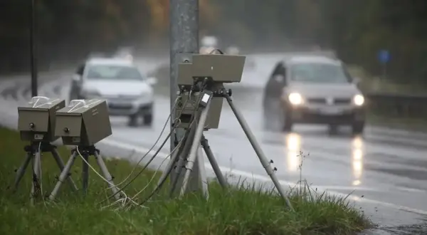 Blitzer am Straßenrand im Regen. Autos fahren vorbei. Wie viel Toleranz bei Blitzern ist erlaubt?