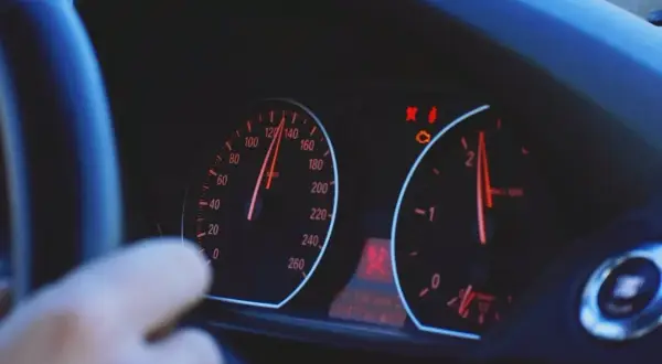Armaturenbrett mit leuchtenden Warnleuchten, darunter die Motorkontrollleuchte, die auf mögliche Motorschaden Symptome hinweist.