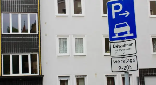 Parken für Bewohner mit Parkausweis werktags 9-20 Uhr, sonst Strafe. Ein blaues Schild mit Auto und Pfeil weist den Weg.
