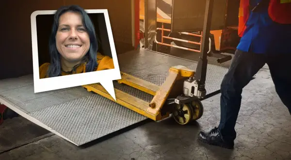Frau lächelt, während ein Gabelhubwagen bereitsteht, um Waren auf dem Gehweg zu be- und entladen.