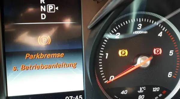 Warnleuchte zeigt Parkbremse Fehler an. Die Anzeige "Parkbremse s. Betriebsanleitung" erscheint im Display.
