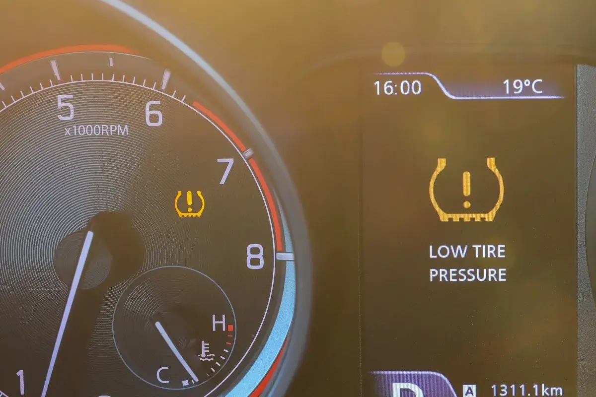 Warnleuchte für **druckverlust reifen** leuchtet auf dem Armaturenbrett. Die Anzeige zeigt "LOW TIRE PRESSURE".