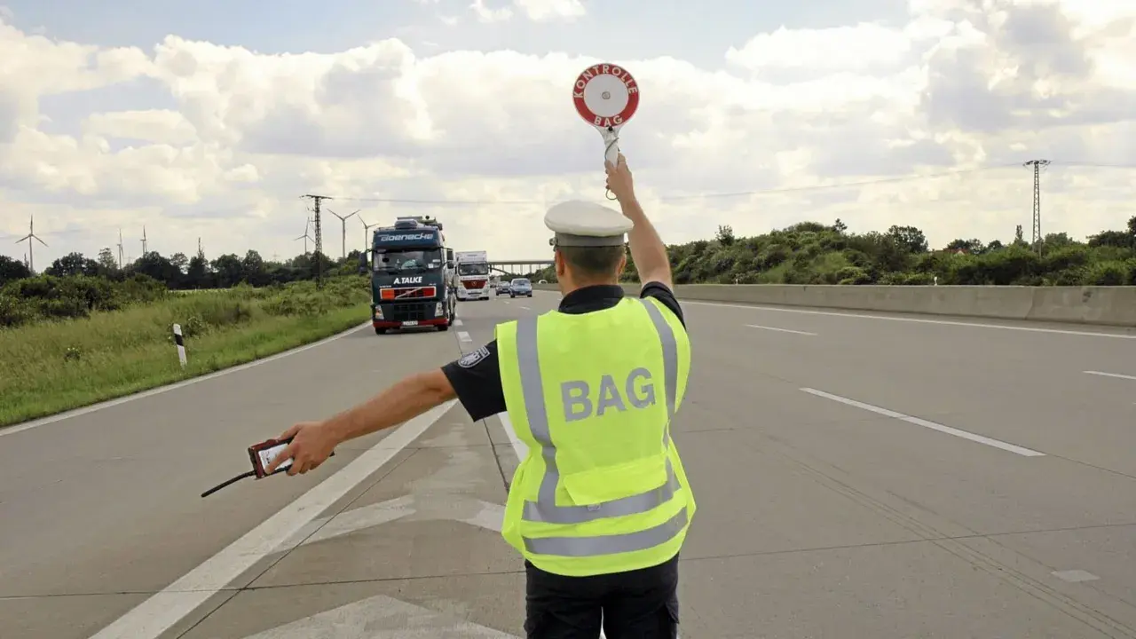 BAG-Kontrolleur regelt den Verkehr auf der Autobahn. LKW werden angehalten.