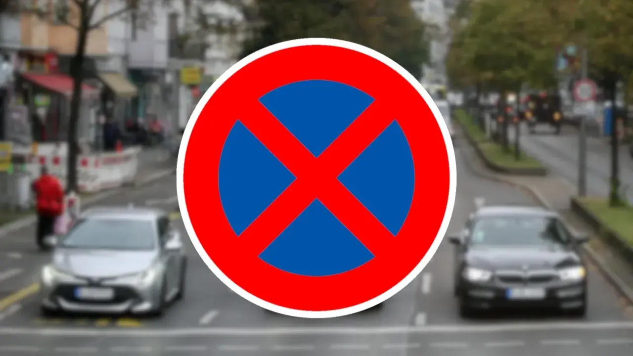 Verkehrsschild "Absolutes Halteverbot". Parken im absoluten Halteverbot strafe droht. Autos fahren auf einer Straße.