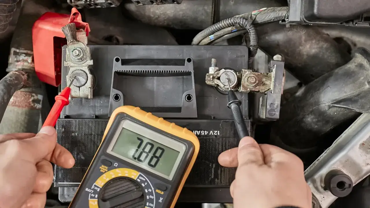 Messung der Autobatterie mit einem Multimeter. Die Anzeige zeigt 7.88 V, was Aufschluss dar&uuml;ber gibt, wie viel Ampere eine Autobatterie haben kann.