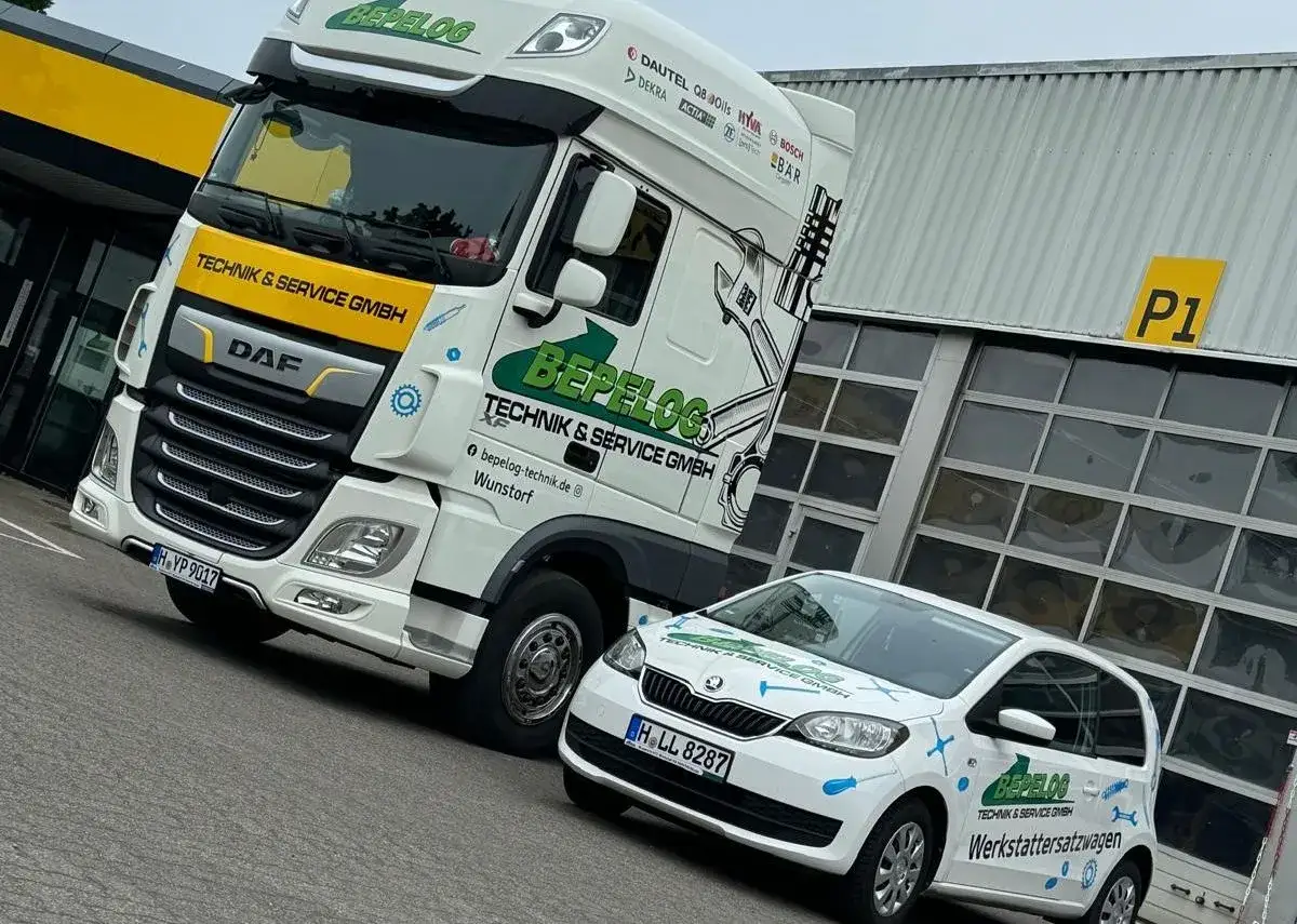 Ein LKW und ein Kleinwagen der Firma BEPELOG stehen vor einer Werkstatt. Die Fahrzeuge sind mit Werkzeugmotiven und dem Schriftzug 