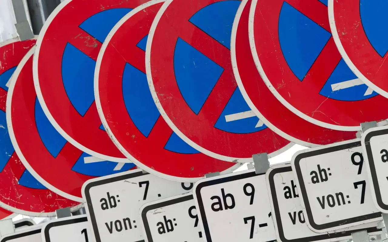 Viele rote und blaue Verbotsschilder stapeln sich. Darunter sind Zusatzschilder mit Zeiten, die auf ein absolutes Halteverbot hinweisen.