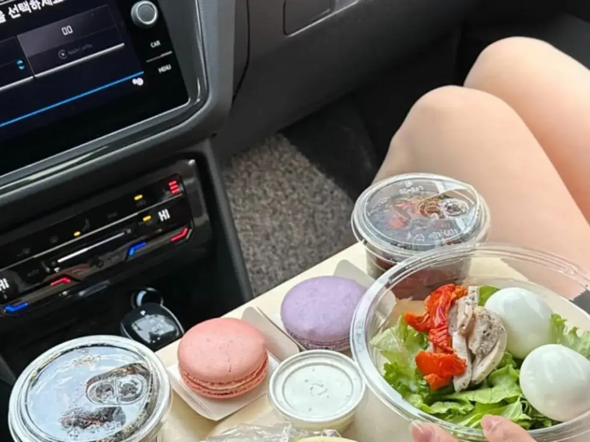 Leckereien im Auto: Salat, Eier, Macarons und Getr&auml;nke. Ob man beim Autofahren essen darf, ist eine andere Frage.