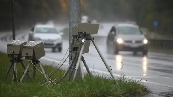 Blitzer am Straßenrand im Regen. Autos fahren vorbei. Wie viel Toleranz bei Blitzern ist erlaubt?