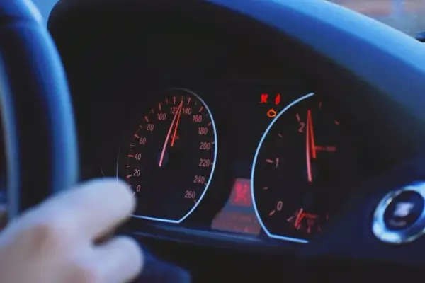 Armaturenbrett mit leuchtenden Warnleuchten, darunter die Motorkontrollleuchte, die auf mögliche Motorschaden Symptome hinweist.
