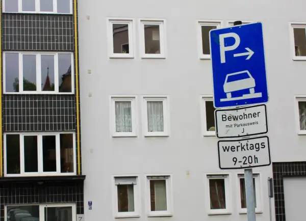 Parken für Bewohner mit Parkausweis werktags 9-20 Uhr, sonst Strafe. Ein blaues Schild mit Auto und Pfeil weist den Weg.