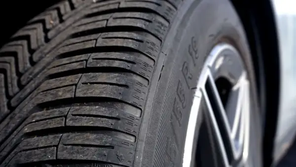 Nahaufnahme eines Autoreifens mit sichtbarem Profil. Die Frage, wie lange halten autoreifen, hängt von vielen Faktoren ab.
