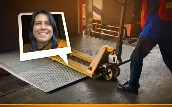 Frau lächelt, während ein Gabelhubwagen bereitsteht, um Waren auf dem Gehweg zu be- und entladen.